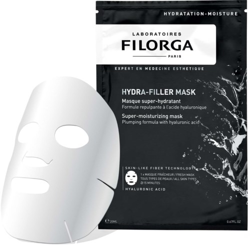 Eine weiße Gesichtsschutzmaske liegt neben einer schwarzen Packung mit Filorga Hydra-Filler Mask mit Beschreibung.