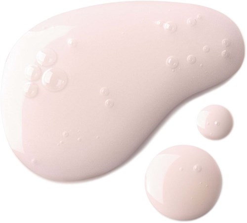 A white liquid drops and spots on a surface, with two rounded drops nearby.