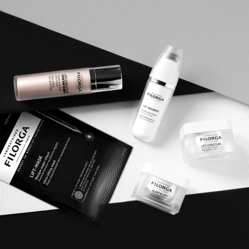 Hautpflegeprodukte mit Etiketten, darunter Maske, Creme und Flaschen, auf schwarzem und weißem Hintergrund angeordnet.