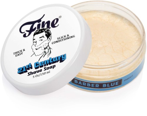 A round container of hair shaving soap with a lid showing a man and text, and the soap inside is beige.