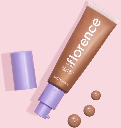 En tub märkt 'Florence' med lila lock och tre små färgprover av beige grundfärg. Ljust rosa bakgrund.