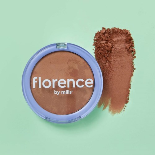 En kompakt med matt puder och varumärket Florence by Mills på locket, med lite puder som spillts bredvid.