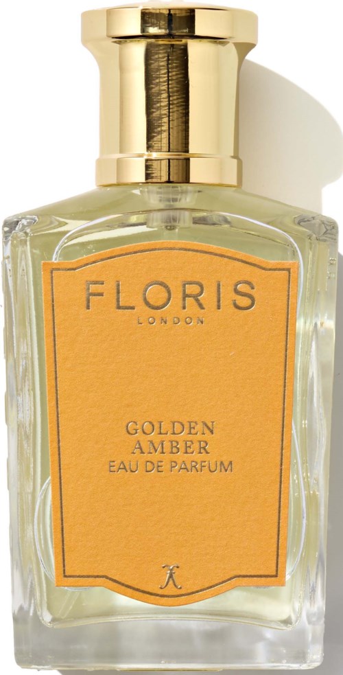 Szklana butelka perfum z złotym korkiem i żółtą etykietą z napisem 'Floris Golden Amber Eau de Parfum.'