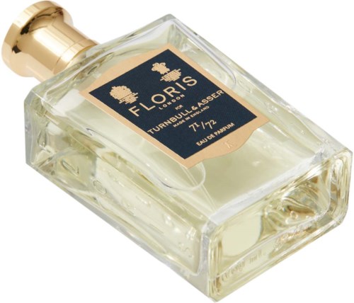 Eine Glas-Parfüm-Flasche mit goldener Kappe und einem Etikett, das 'Floralis Turnbull Lasseur 77/72 Eau de Parfum' sagt.