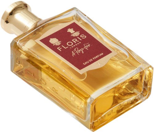 Een parfumfles met het label "Flororis" en gouden vloeistof en een gouden dop.