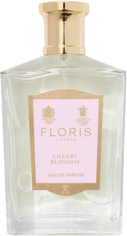 Eine klare Parfümflasche mit goldener Kappe und einem pinken Etikett, auf dem 'Cherry Blossom' steht, von Floris London.