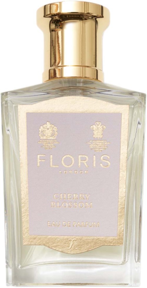 Een doorzichtige parfumfles met een gouden dop, gelabeld 'Cherry Blossom' en 'Floris London' in lichtpaars en goud.