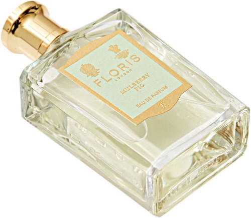 Een glazen parfumfles met een gouden dop, label 'Mulberry Fig' en 'Floris'.