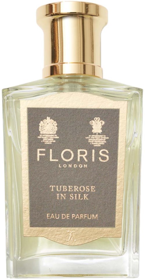 Een glazen parfumfles met gouden dop, met label "Floris London" en "Tuberose in Silk."