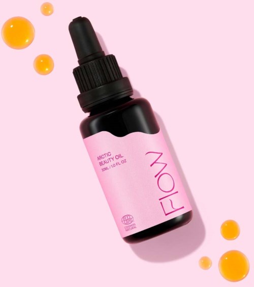 Roze fles met 'FIO' label en pipetdop, omgeven door gele-oranje druppels, op roze achtergrond.