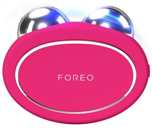 Een roze apparaat met twee metalen blauwe en zilveren ballen bovenop, en het woord "FOREO" in het midden.