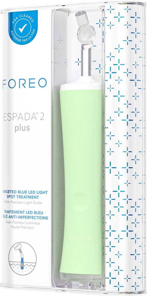 Een groen handapparaat in een plastic doos, met label "FOREO ESPADA 2 plus," voor huidbehandeling met blauw LED-licht.