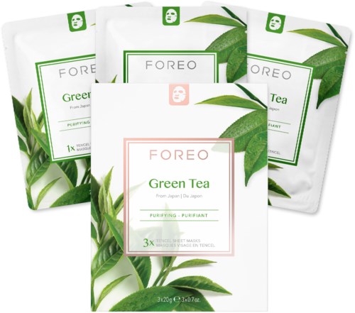 Vijf verpakkingen van FOREO Green Tea gezichtsmaskers met groen theeblad ontwerp. De verpakkingen zijn wit en groen, deels overlappend.