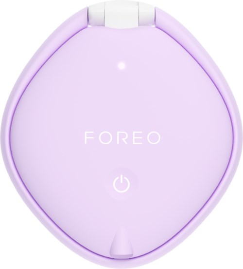 En ljus lila, rund ansiktsapparat med knappar märkte 'FOREO' och strömikon, som lyser svagt.