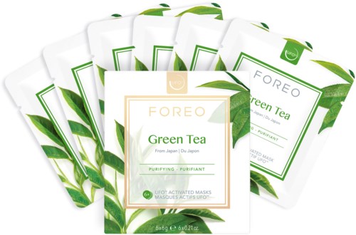 Meerdere gezichtsmaskerpakketten met 'FOREO Green Tea' en groene thee bladeren op de achtergrond.