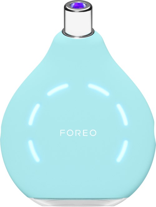 Vaaleansininen laite pyöreä muoto, jossa lukee 'FOREO'. Se on todennäköisesti kauneus- tai ihonhoitolaite.