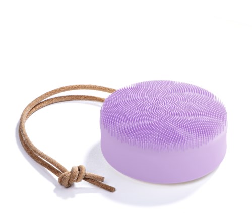 Een paarse ronde gezichtsreinigingsborstel met een bruin bandje voor vastmaken of ophangen.