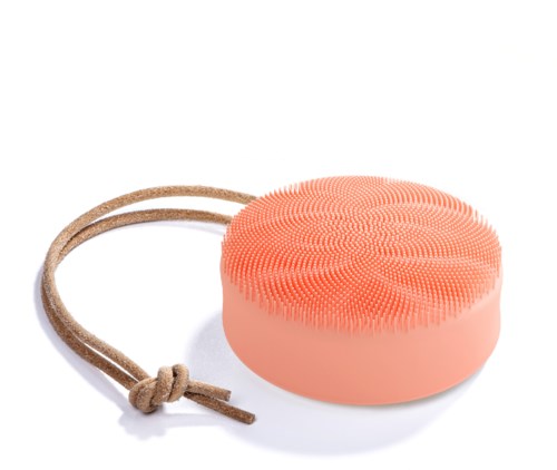 Een ronde, roze siliconenborstel met kleine borstels en een bruin leren ophangkoord.