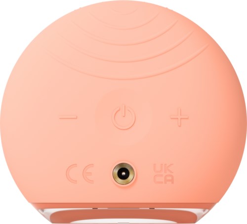 Een roze ronde apparaat met een aan/uit-knop, volumeregeling en luidsprekerrooster aan de bovenkant.