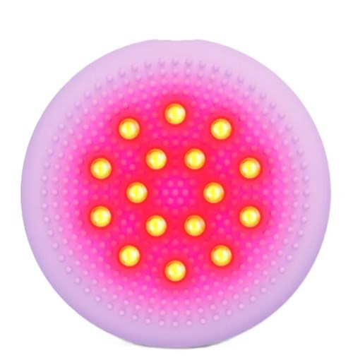 A circular device with small yellow lights on a pink background, possibly a massage or therapy tool.