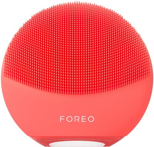 Een roze, ronde gezichtsreinigingsapparaat met kleine siliconenborstels en de merknaam 'FOREO'.