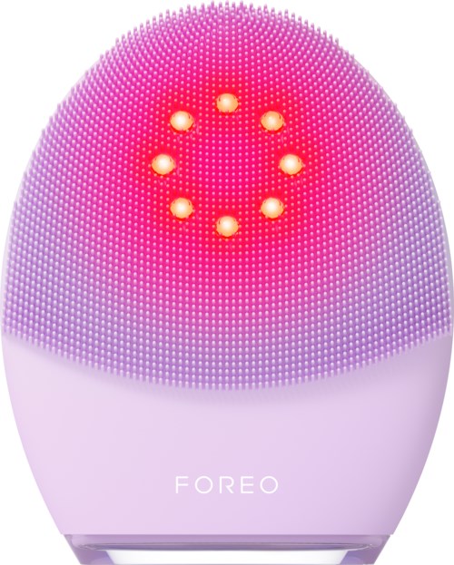 Een paarse en roze gezichtsreinigingsapparaat met een gloeiende ring en veel kleine siliconenborstels.