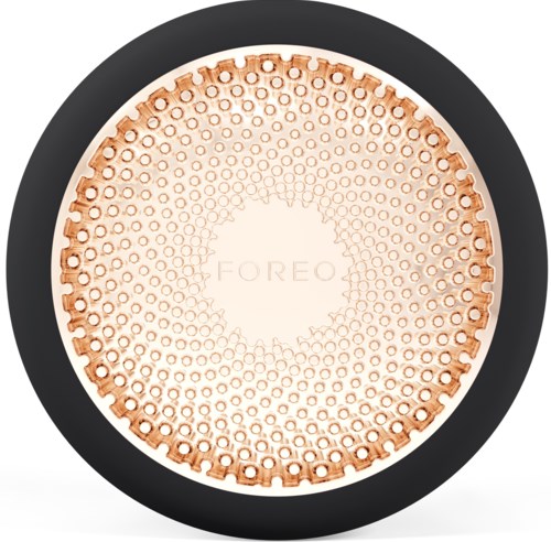 Een ronde huidverzorgingsapparaat met kleine gaatjes, met 'FOREO' erop, in een zwarte rand.