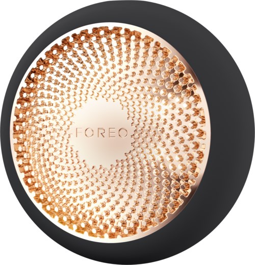 Een ronde cosmetica container met een glanzende roségouden deksel met een getextureerd patroon en de merknaam 'FOREO' binnenin.