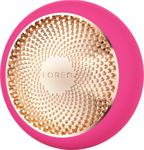Een ronde apparaat met een roze rand en een goudkleurige patroonoppervlak, met de merknaam "FOREO" in het midden.