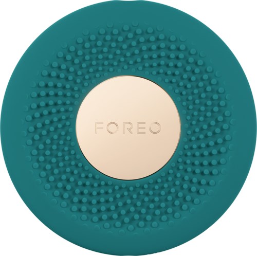 Een teal, ronde apparaat met kleine knoppen rond het midden, met 'FOREO' erop.