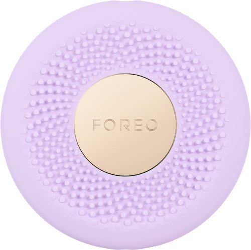 Een ronde Foreo-apparaat met een gestructureerde paarse buitenkant en een centrale beige plek met de merknaam.