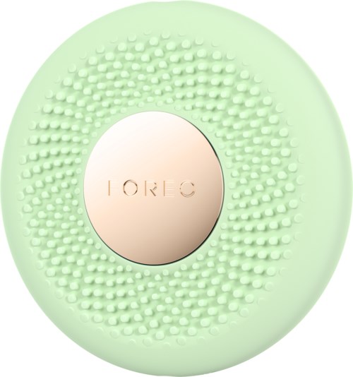 Een ronde, mintgroene huidverzorgingsapparaat met kleine siliconenborstels en een centrale metalen cirkel met 'FOREO'.