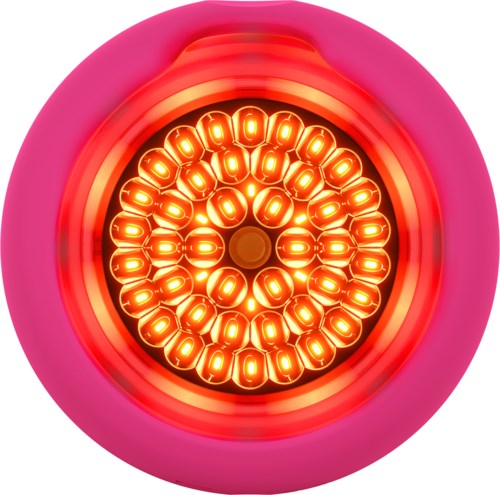 Een roze ronde voorwerp met een gloeiend, cirkelvormig lichtpatroon aan de binnenkant, lijkt op een futuristisch apparaat.