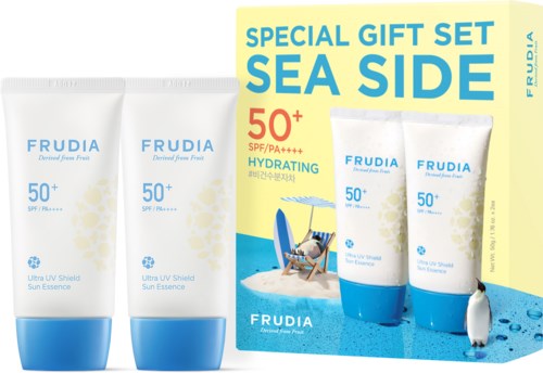 Zwei Tuben Sonnencreme und eine Schachtel, alle mit 'FRUDIA' etikett, mit Strandbild und Pinguin auf der Schachtel.
