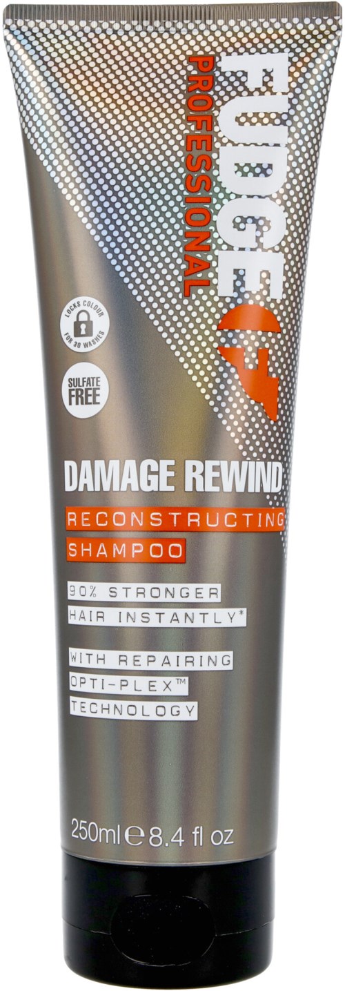 Een zilveren tube shampoo met oranje en witte tekst, gelabeld voor het herstellen van beschadigd haar en versterken.