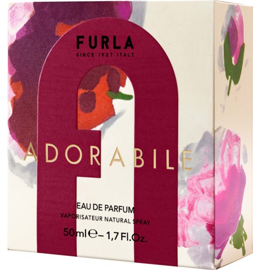 En parfymkartong med en rosa bokstav 'Q' och blommiga mönster, visar att det är från det italienska märket Furla sedan 1927.