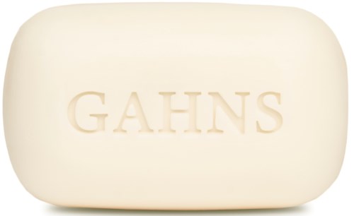 En vit tvål med ordet "GAHNS" präglat på, rund och slät yta.