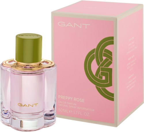 Ein Parfümflasche mit rosa Flüssigkeit und grünem Deckel neben einer rosa Box mit goldener und grüner Logo und Text.