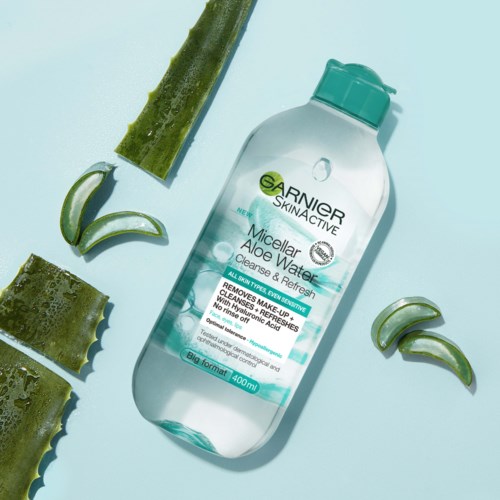 A bottle of Garnier Micellar Aloe Water surrounded by aloe vera slices and aloe leaves.