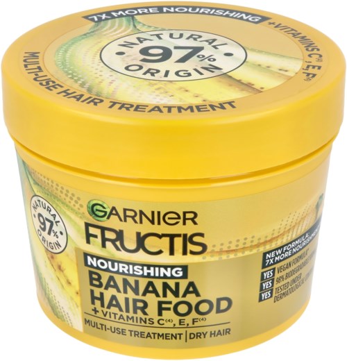 Gul behållare för hårvård med gröna och svarta texter, visar en banan och nämner naturliga ingredienser.