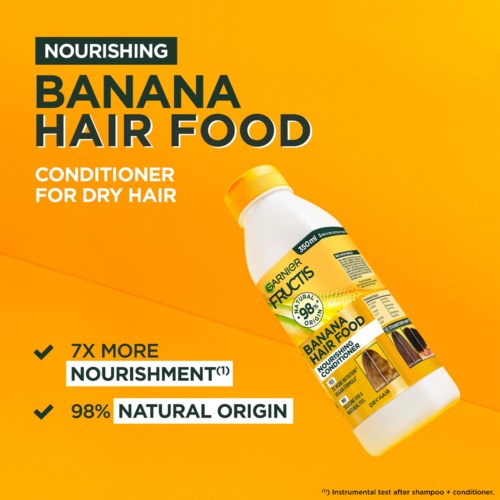 Geel achtergrond met een witte fles Banaan Haarvoeding. Tekst benadrukt voordelen zoals "7x meer voeding" en "98% natuurlijke oorsprong."