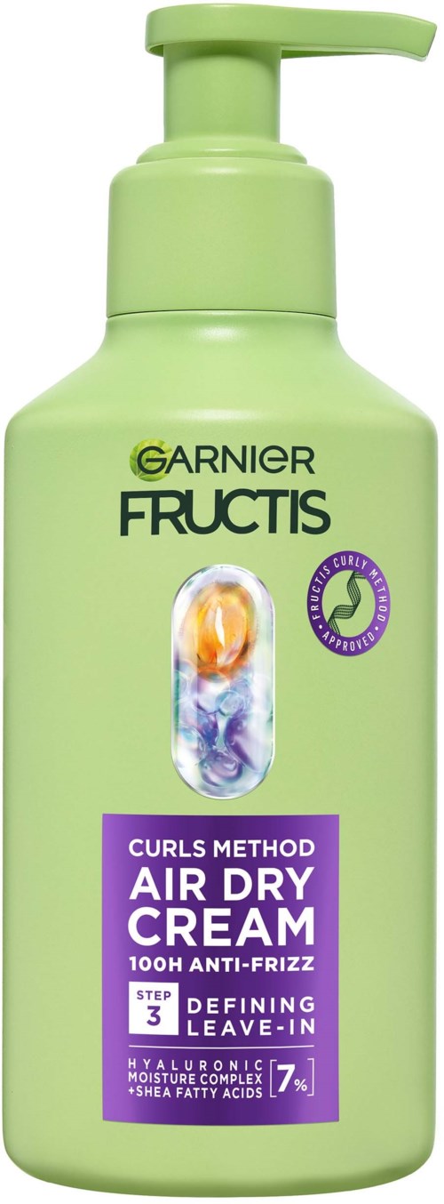 En lys grønn flaske med pumpe, merket Garnier Fructis lufttørkekrem for krøllete hår med anti-frizz teknologi.