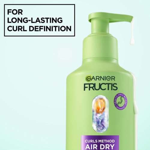 Grønn Garnier Fructis sjampo-flaske med pumpe, merket for langvarig krølldefinisjon.