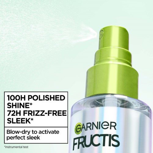 En sprayflaska märkt Garnier Fructis som pratar om glans och tamning av frissighet. Den sprayar ett moln.
