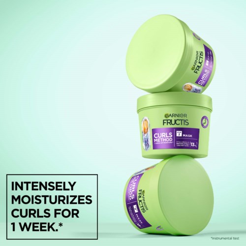 Drie groene potten Garnier Fructis haarmasker gestapeld, met tekst over het hydrateren van krullen voor een week.