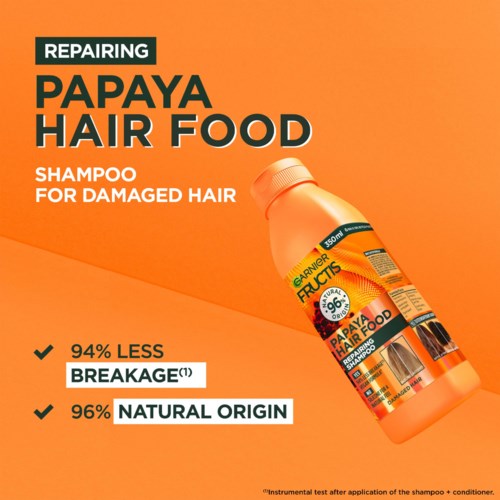 Fles shampoo genaamd Papaya Hair Food voor beschadigd haar, met beweringen over minder breuk en natuurlijke oorsprong.
