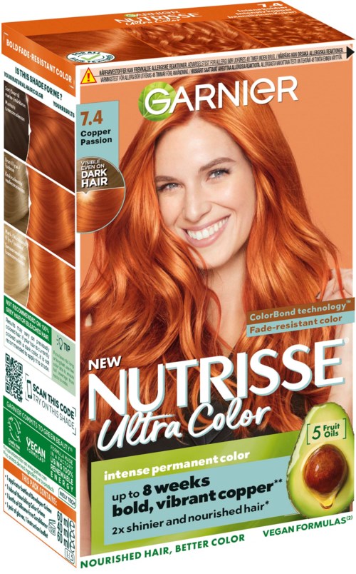 Eine Frau mit langen, welligen roten Haaren lächelt auf einer Haarfärbekarton. Die Verpackung zeigt Haarfarbe und Vorteile.