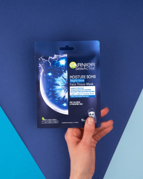 Verpakking van Garnier SkinActive Moisture Bomb Nachtgezichtsmasker tegen donkerblauwe achtergrond.