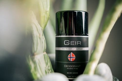 Een zwarte deodorant with Noorse vlag, tussen groene bamboestammen.