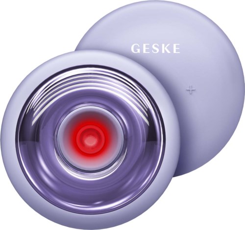 Kleines rundes Gerät mit der Aufschrift 'GESKE', rotem Leuchtezentrum und violettem Licht, möglicherweise ein medizinisches Gerät.